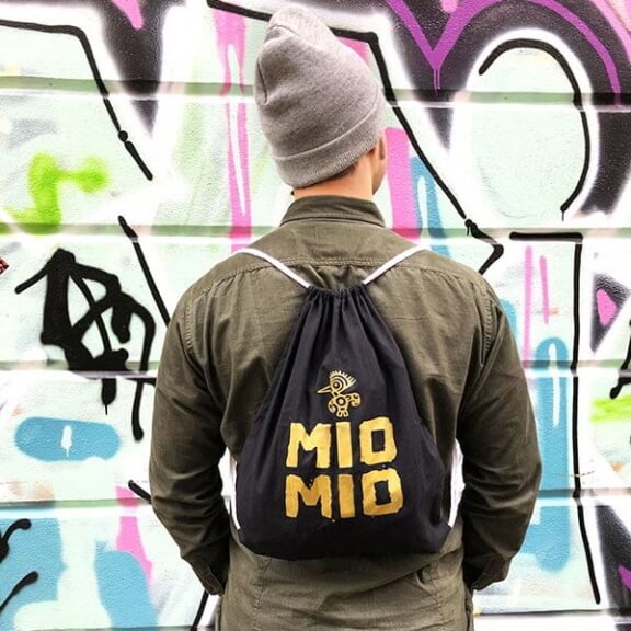Mann trägt Schwarzen Mio Mio Baumwollbeutel mit goldenem Logo