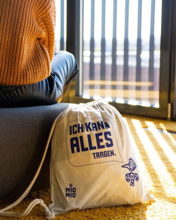 Hellgrauer Mio Mio Baumwollbeutel mit blauem Logo und Schriftzug: Ich kann alles tragen